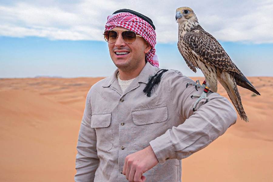 Guest holding a falcon in the desert